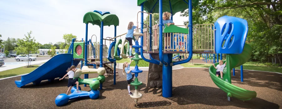 Children Playing Safely on a Certified Playground With Slides and Climbing Structures