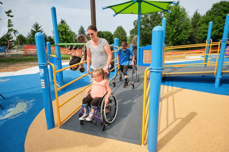 Parent And Child Bonding At A Community Playground With Special Needs Friendly Equipment